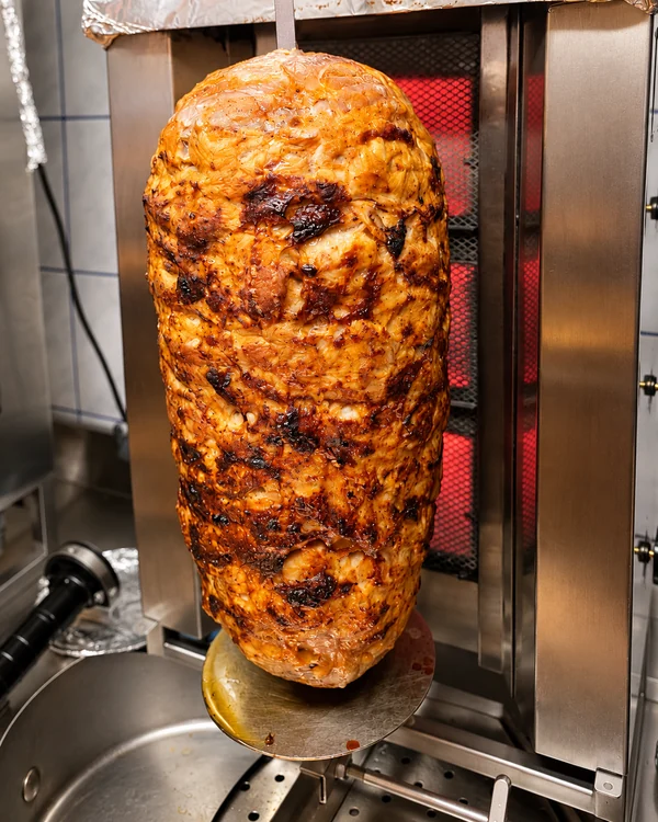 Gebräunter Hähnchen-Drehspieß vor dem Grill bei Haci Baba